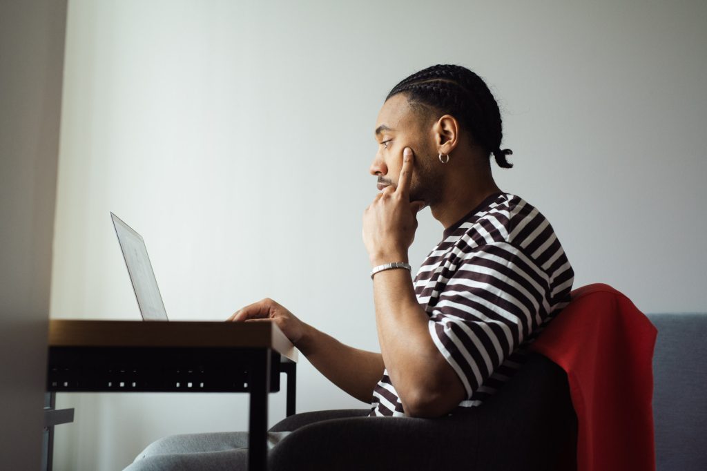 Nuori mies katsoo tietokonetta.