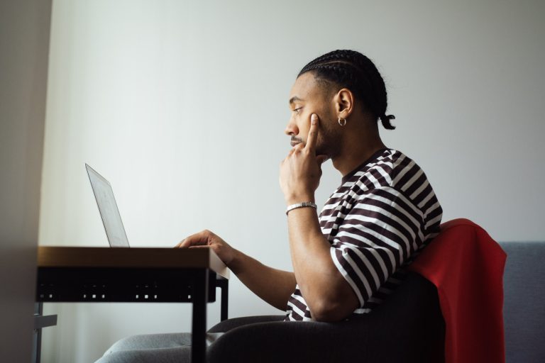 Nuori mies katsoo tietokonetta.